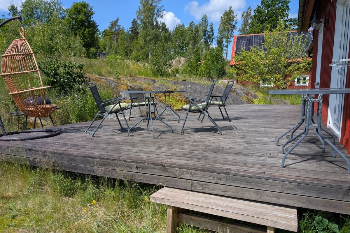 Den stora altanen på baksidan med bord och stolar